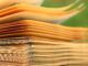 Macro shot of aged book pages with a blurred green background, highlighting texture and detail.