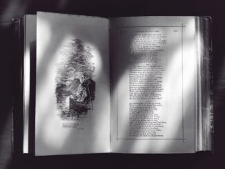 A black and white photo of an open book displaying text and an illustration.