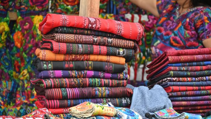 Vibrant handwoven textiles displayed at Sumpango market in Guatemala.