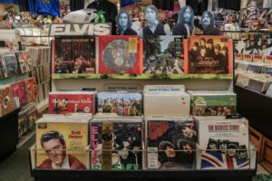 Retro vinyl collection featuring The Beatles and Elvis Presley in a classic music shop.