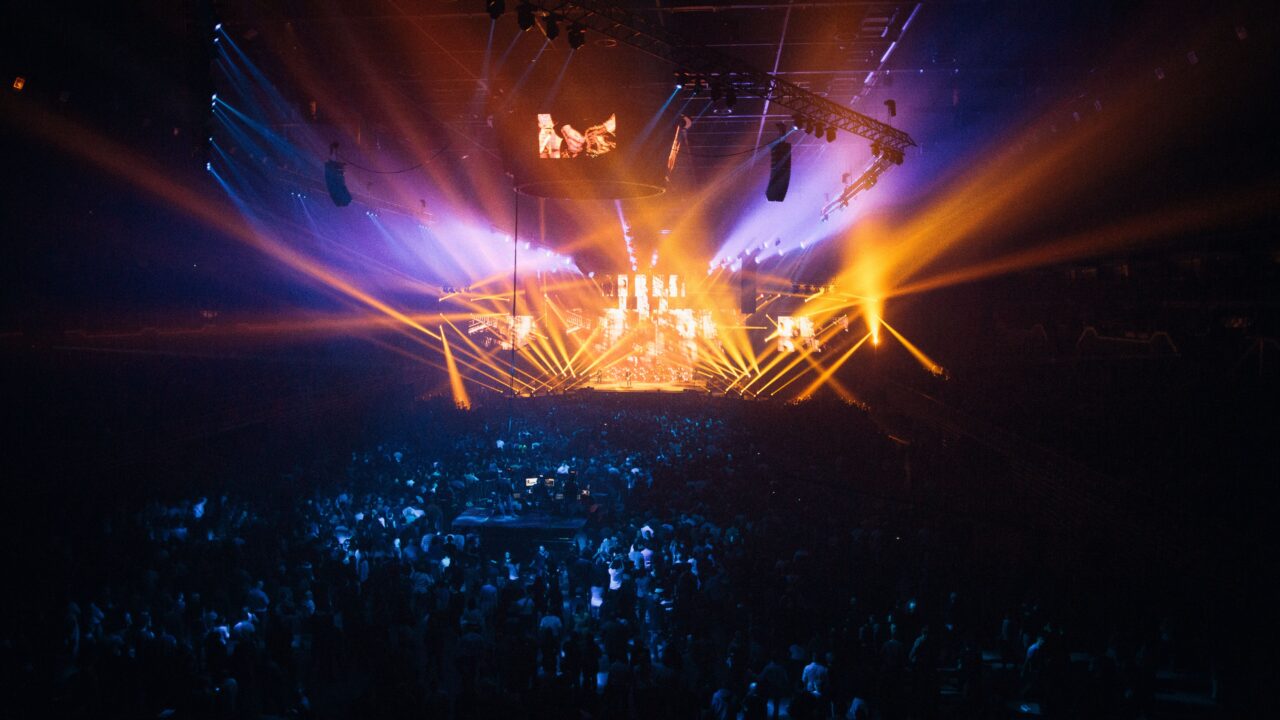 A vibrant live concert with dynamic lighting effects and an enthusiastic crowd.
