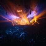 A vibrant live concert with dynamic lighting effects and an enthusiastic crowd.