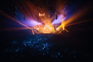 A vibrant live concert with dynamic lighting effects and an enthusiastic crowd.