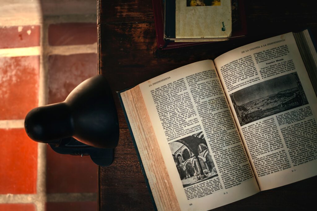 Warm library atmosphere with an open book and desk lamp in soft lighting.