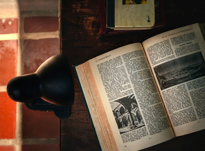 Warm library atmosphere with an open book and desk lamp in soft lighting.