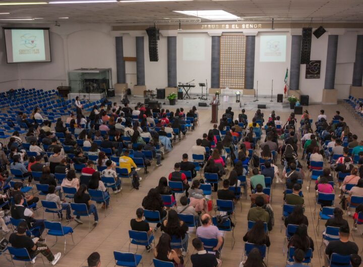 A large audience seated in a church auditorium attending a seminar.
