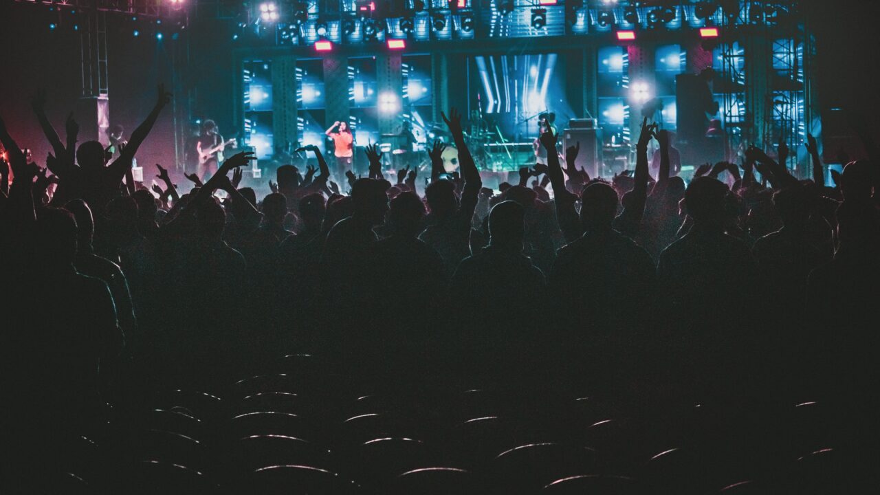 Energetic crowd enjoying a live music concert with colorful lights in Contai, West Bengal, India.
