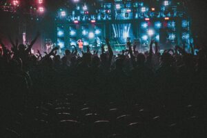 Energetic crowd enjoying a live music concert with colorful lights in Contai, West Bengal, India.