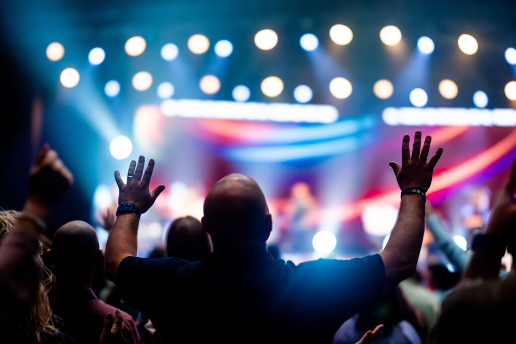 A vibrant scene of concert-goers enjoying a live music performance with colorful stage lights.