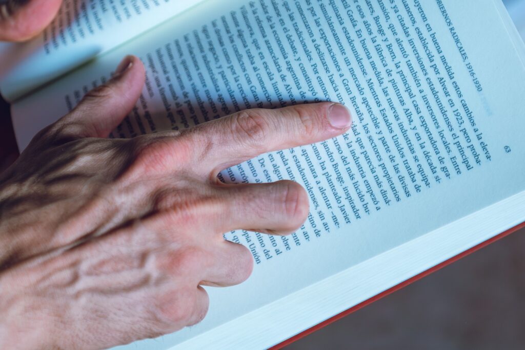 Detailed shot of a person reading a book, focusing on hand and text, in Buenos Aires, Argentina.