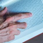 Detailed shot of a person reading a book, focusing on hand and text, in Buenos Aires, Argentina.