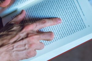 Detailed shot of a person reading a book, focusing on hand and text, in Buenos Aires, Argentina.