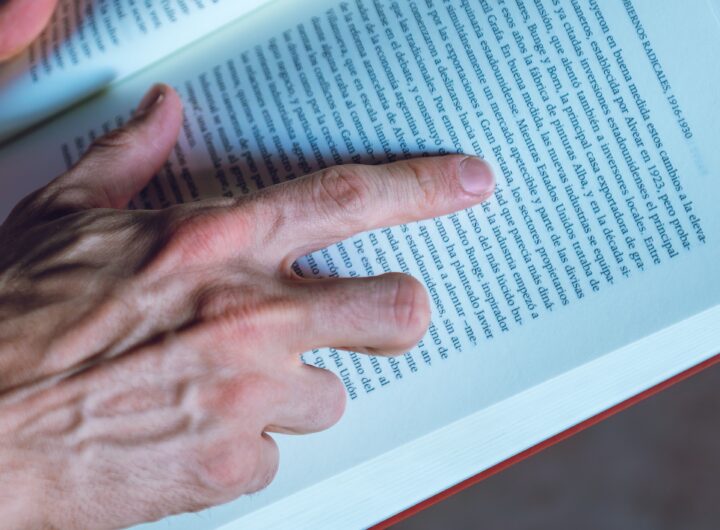Detailed shot of a person reading a book, focusing on hand and text, in Buenos Aires, Argentina.